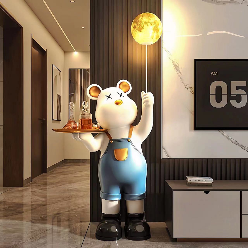 A luxury statue of a cartoon bear in overalls, holding a tray with drinks and touching a wall-mounted moon lamp, in a modern room.