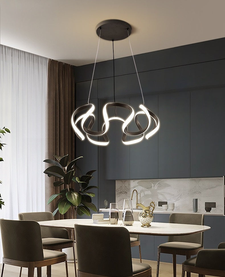 This minimalist modern dining room exudes a Nordic vibe, complete with a sleek dining table and stylish chairs. The space is beautifully illuminated by the striking Ohm Pendant Light.