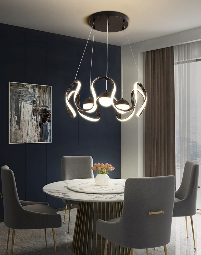 A minimalist dining room with a Nordic vibe, featuring a dining table and chairs illuminated by a pendant light.