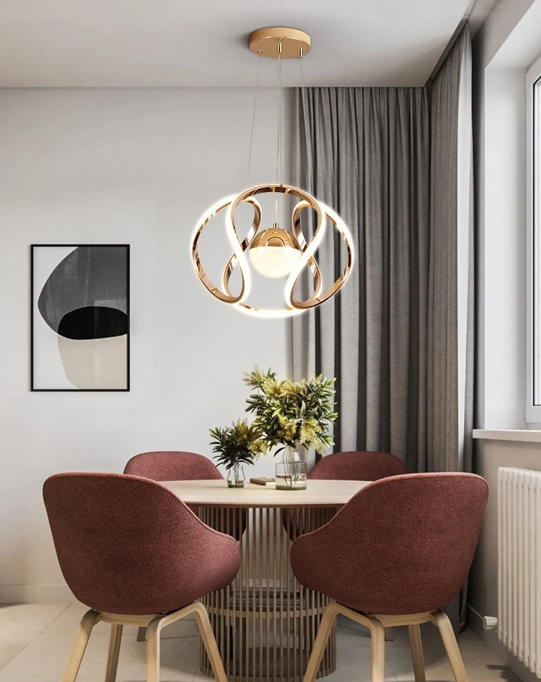 A modern Nordic dining room with a dining table and chairs illuminated by a pendant light.