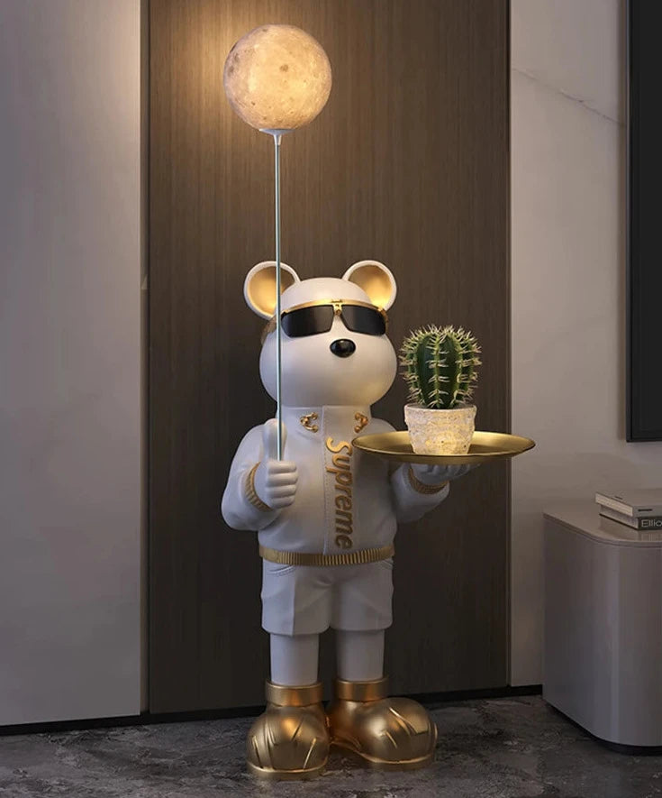 A cartoonish, anthropomorphic white bear wearing sunglasses, a Supreme hoodie, and gold shoes stands holding a tray with a cactus, serving as a unique Bear Statue Night Light with a moon-shaped light
