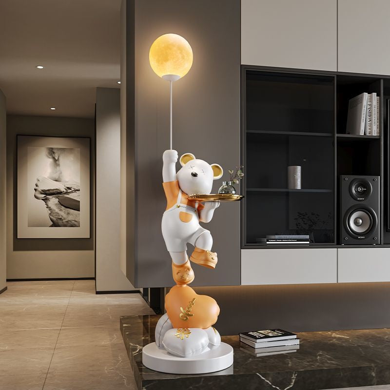 A whimsical statue of three stacked bears in a modern living room, creating a welcoming atmosphere, with the top bear reaching for a glowing moon-shaped lamp.