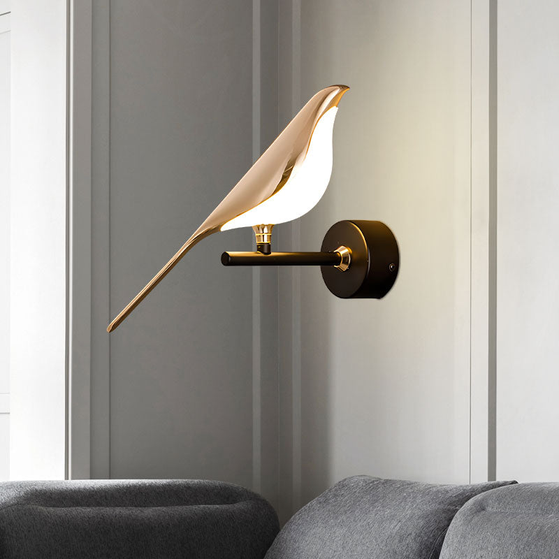 A modern Bird Wall Light, designed as an accent piece for interior design, is mounted above a gray sofa.