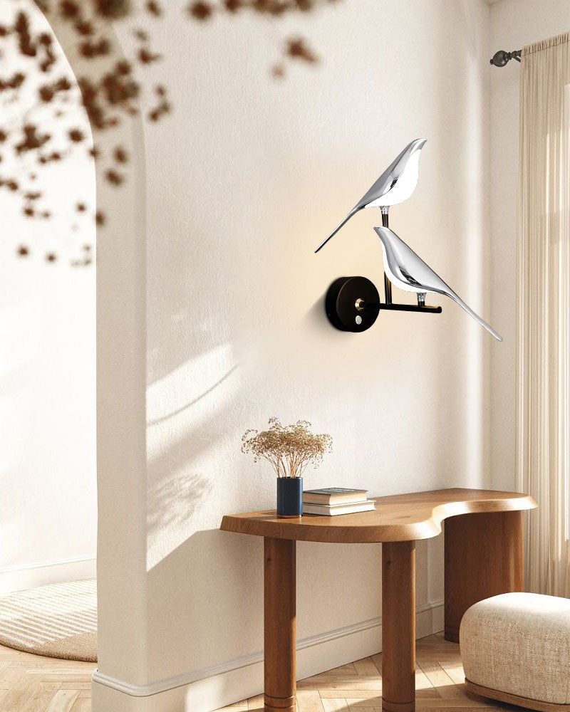Seagull perched on a Bird Wall Light indoors, overlooking a minimalist room with a wooden table and dried flowers.