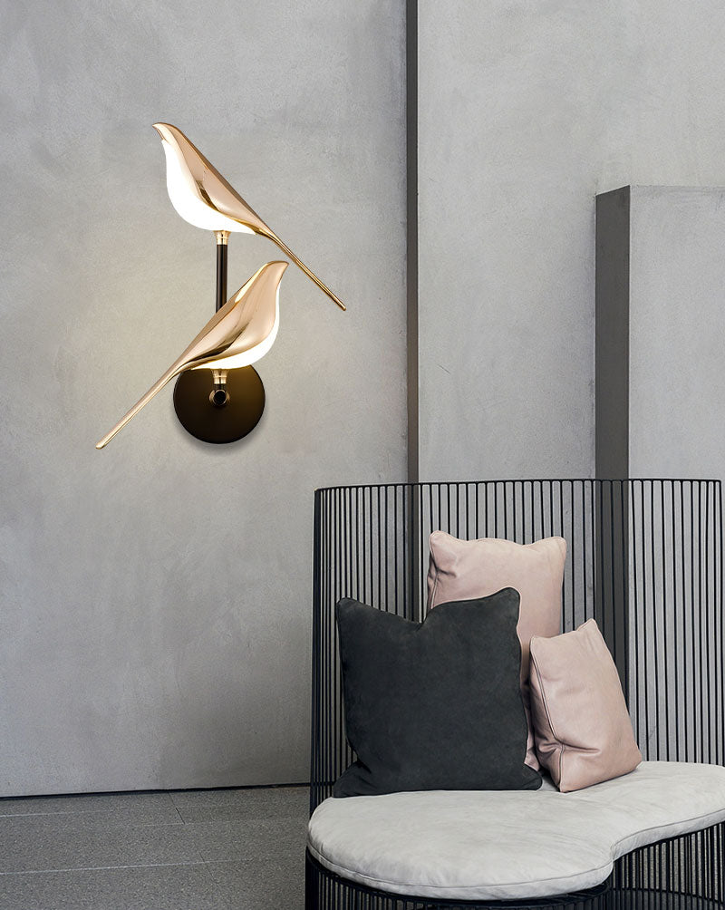 Modern Bird Wall Light resembling a bird over a contemporary daybed with pillows in a minimalist interior design.