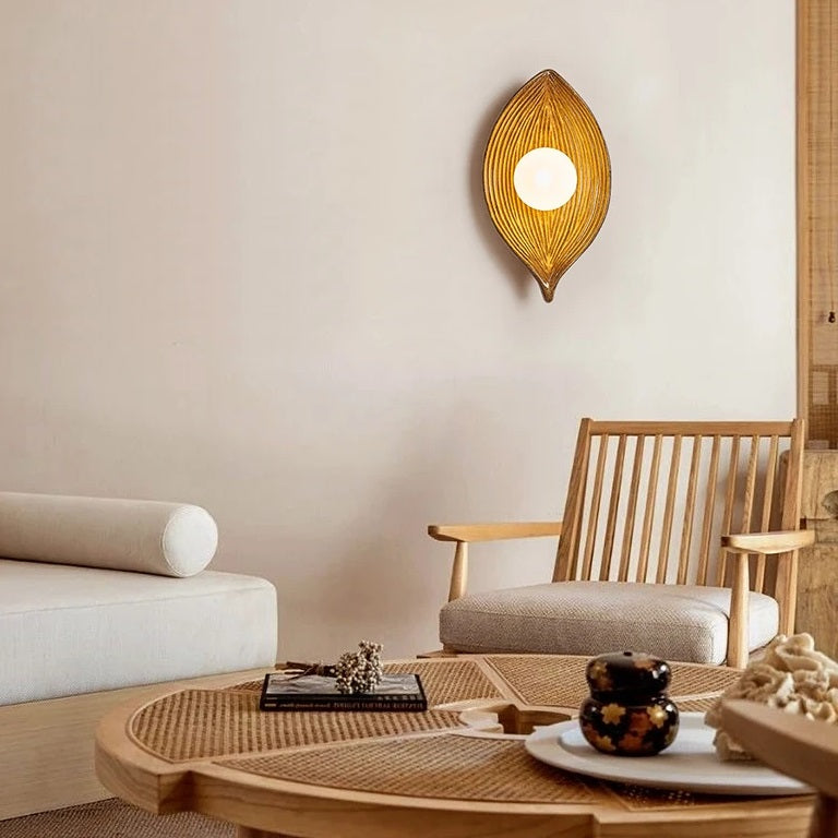 A living room with a wooden table and chairs illuminated by a Leaf Wall Light, bringing a touch of nature to the indoor lighting.