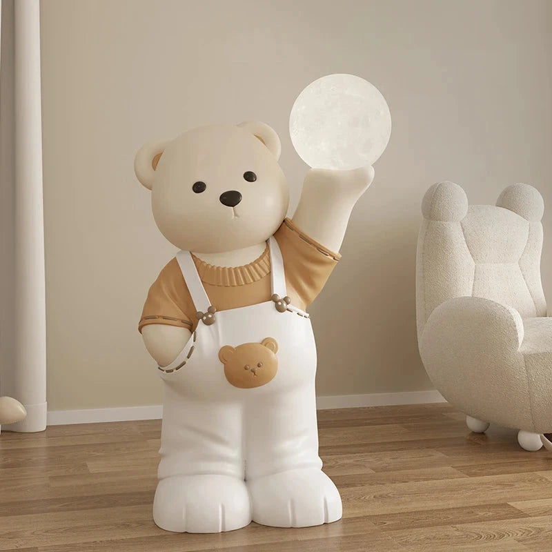 A large, modern-style bear-shaped lamp with a glowing orb in its raised hand, dressed in white overalls and a brown shirt, standing in a room.