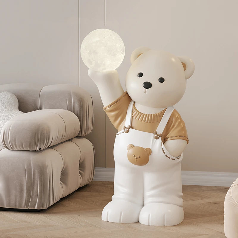 A large decorative bear art piece shaped like a cartoon bear holding up a glowing orb, placed next to a couch in a softly lit room.