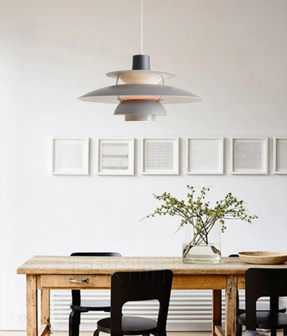 A dining room with a Danish Layered Pendant Light hanging gracefully above a wooden table and chairs.