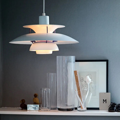 A Danish Layered Pendant Light, with its minimalist layered look, gracefully hangs above a gray shelf in modern homes.