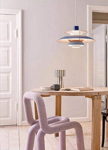 A dining room with a purple chair and table, featuring a stylish pendant light that enhances its overall aesthetic.