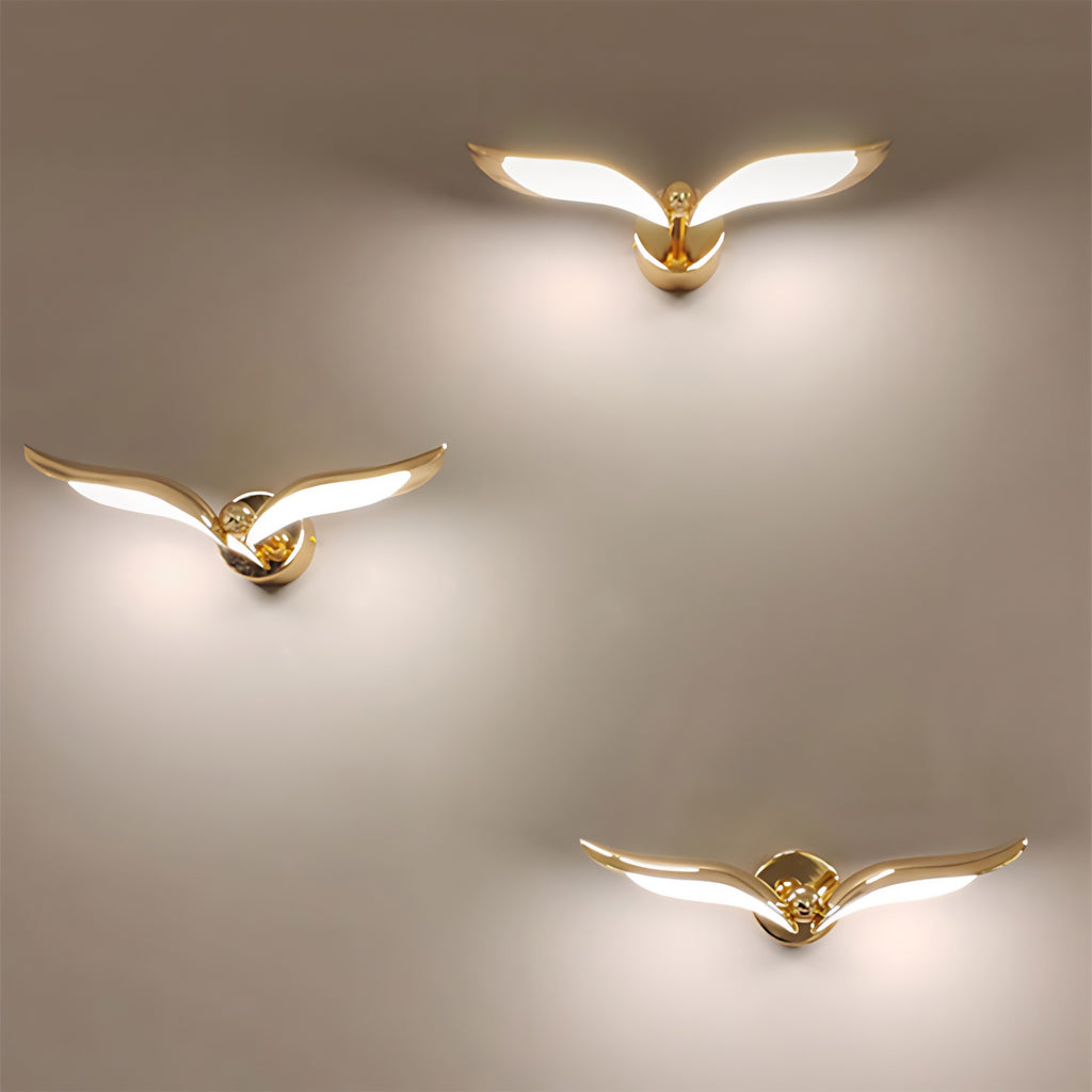 Three gold wing shaped Flying Bird Wall Lights adorn the interior wall, enhancing the elegant ambiance of home's decor.