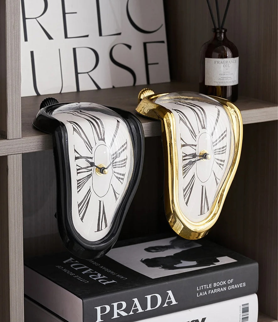 Two Salvador Dali-inspired clocks with a unique twist, sitting on top of a shelf.