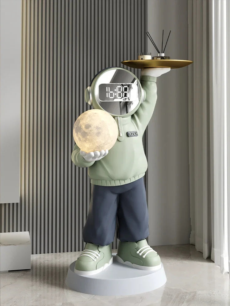 Decorative astronaut-themed clock of a cartoon-style astronaut holding a moon replica and a serving tray with a soothing night light for a head, standing in a modern room.