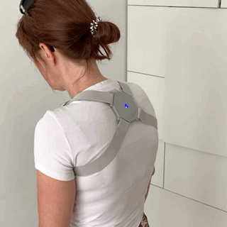 A woman wearing a SmartPro™ Spine Corrector with auto alert and vibration for bad posture.