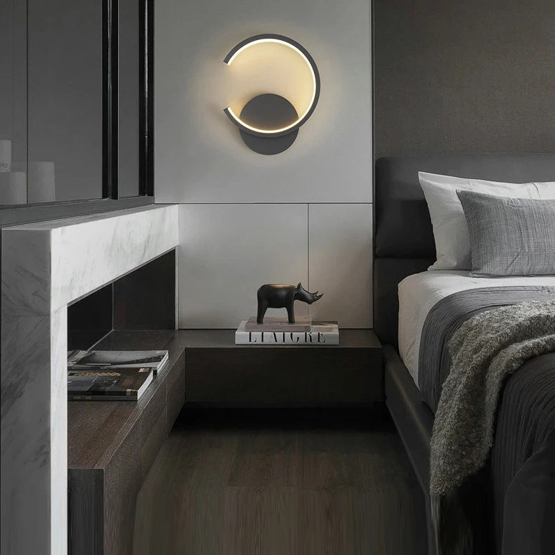 A contemporary bedroom with a bed and a black Nordic wall sconce.