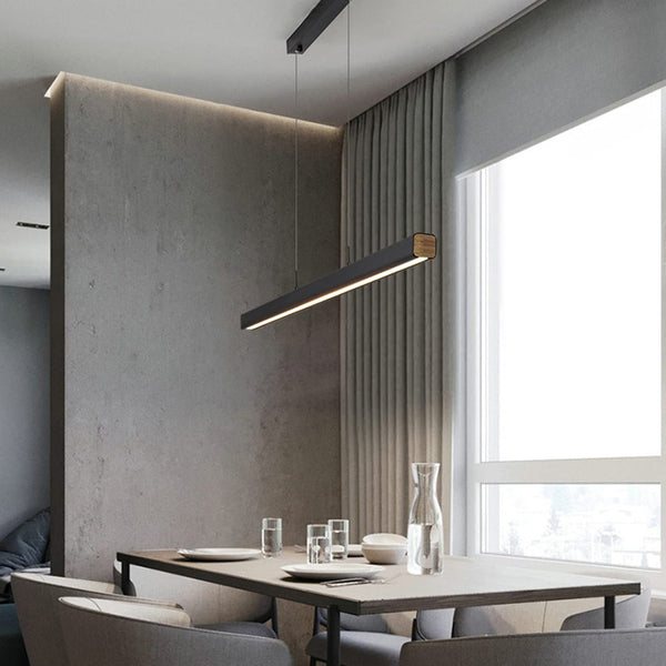 A modern dining area with a grey table and chairs under the modern pendant light.