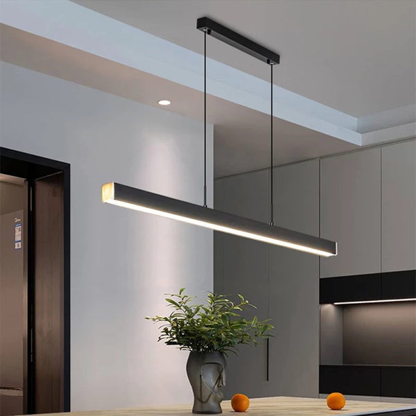 A sleek kitchen with a modern pendant light in the dining area.