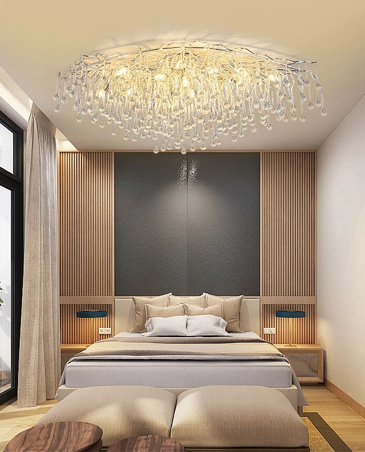 A modern bedroom with a bed and an opulent crystal chandelier adorned with tear drop crystals.