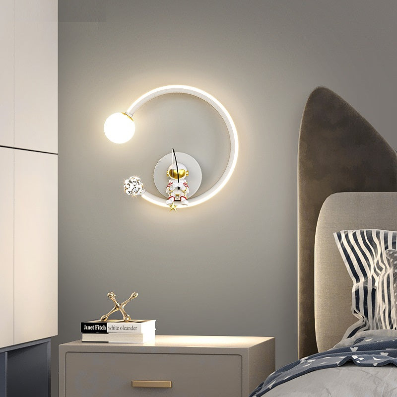 Modern wall-mounted Star Astronaut Wall Light with a celestial wonder design and decorative elements next to a bed.