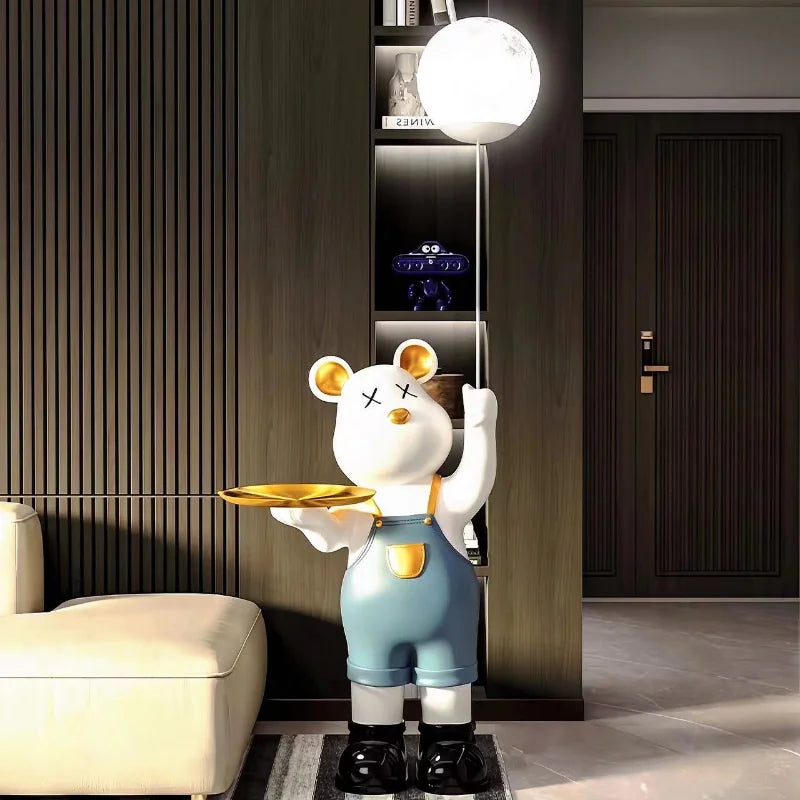 Luxury standing bear statue of a cartoon bear in overalls holding a tray, positioned in a modern living room.