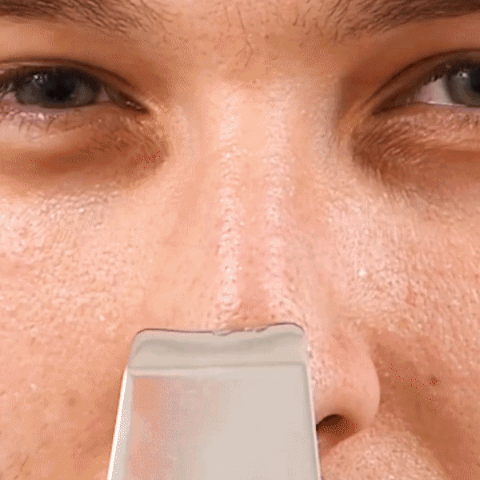 A man's skin is being pierced with a nose cleaning tool.