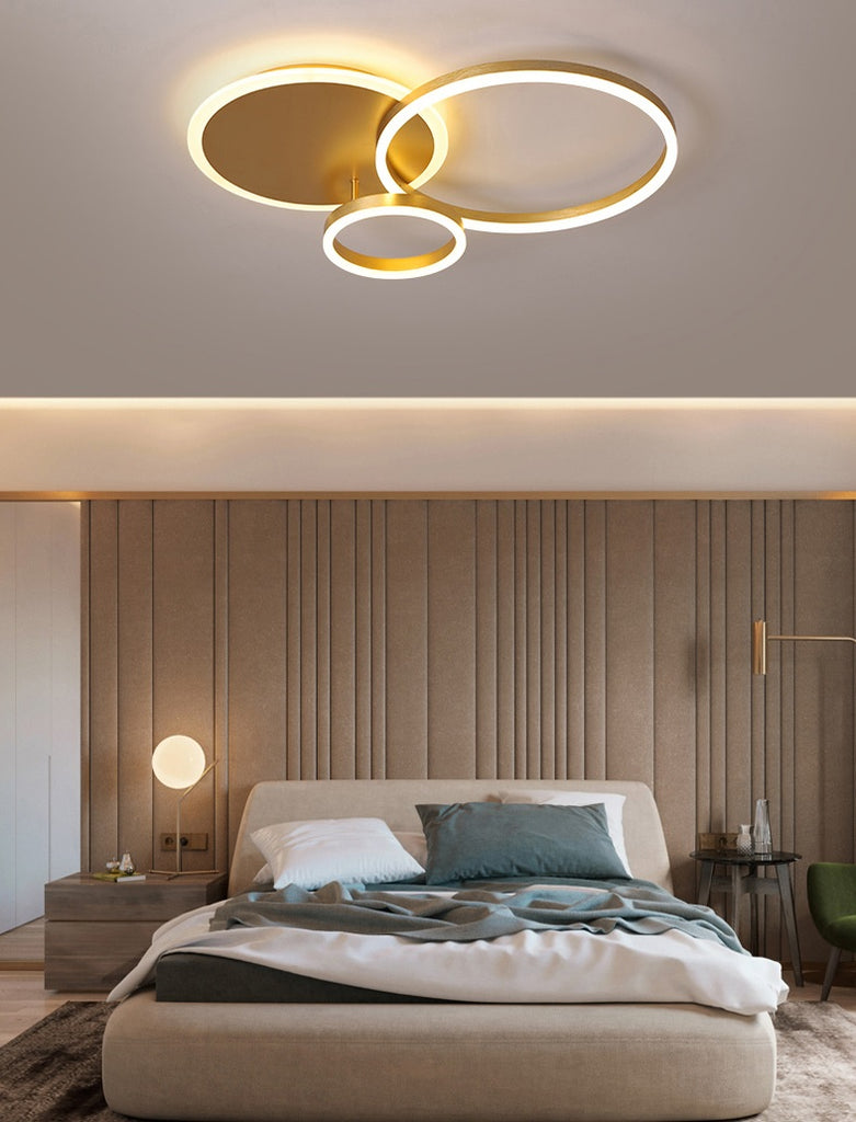 A modern bedroom with interlocking ring ceiling lamp.