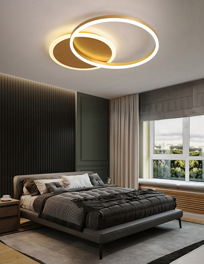 A modern bedroom with an interlocking rings ceiling lamp.