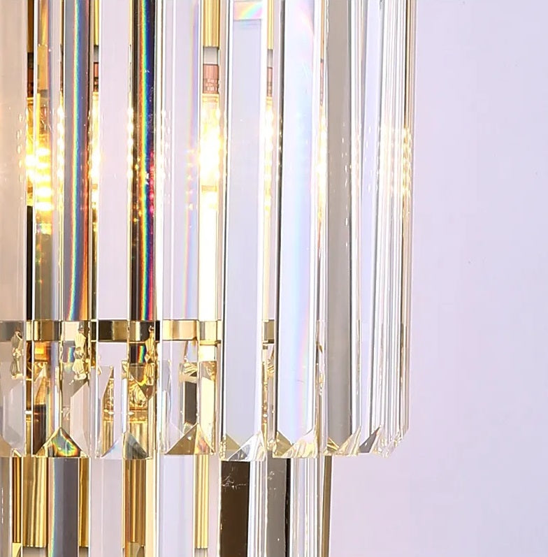 A modern crystal wall light refracting light onto a white wall.