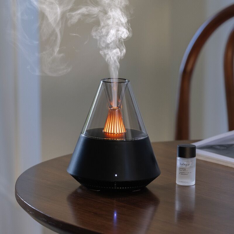 An ultrasonic Essential Oil Diffuser SpyCam releasing vapor on a wooden table.