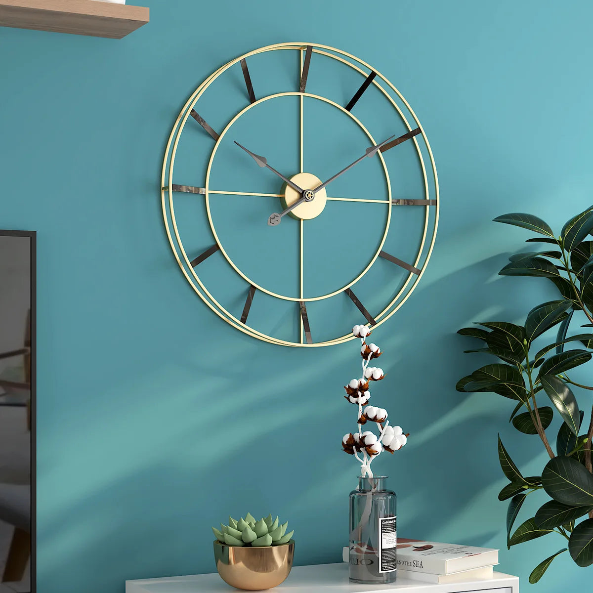 A modern geometric design wall clock with a minimalist design against a turquoise wall, above a small shelf with decorative items.