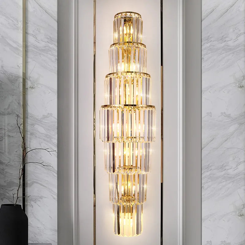 A modern gold wall sconce with crystal strands.