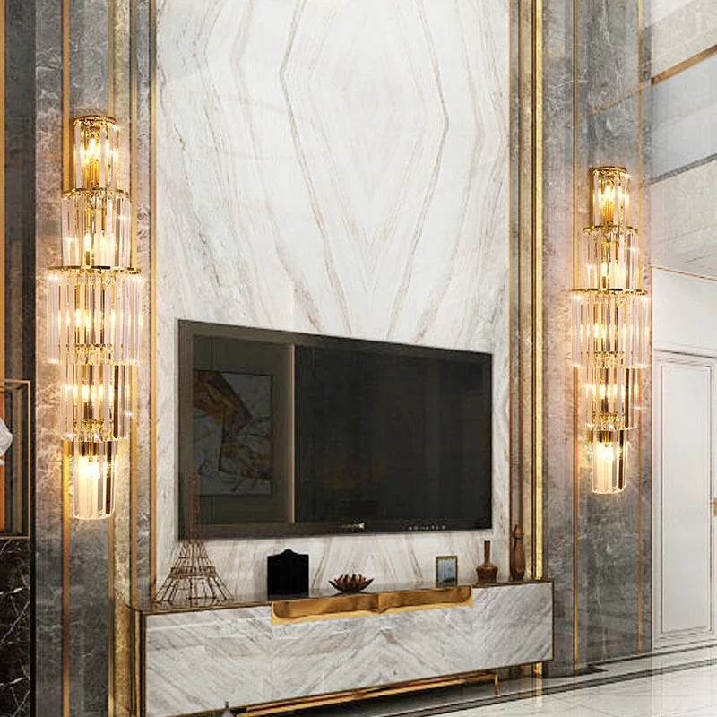 A living room with sparkling gold and marble walls and a modern crystal wall light.