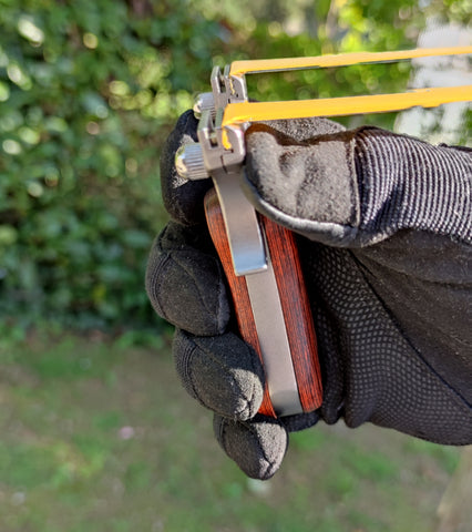 Resting on a slingshot: the fat of the thumb and the base of the index finger rest on each branch while the remaining 3 fingers grip the handle 1