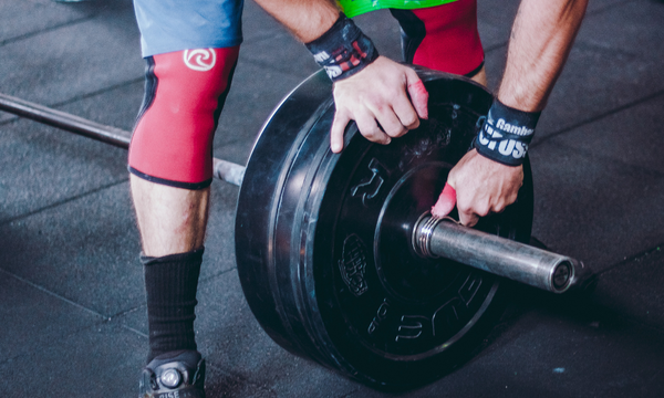 Person holding black bumper plate