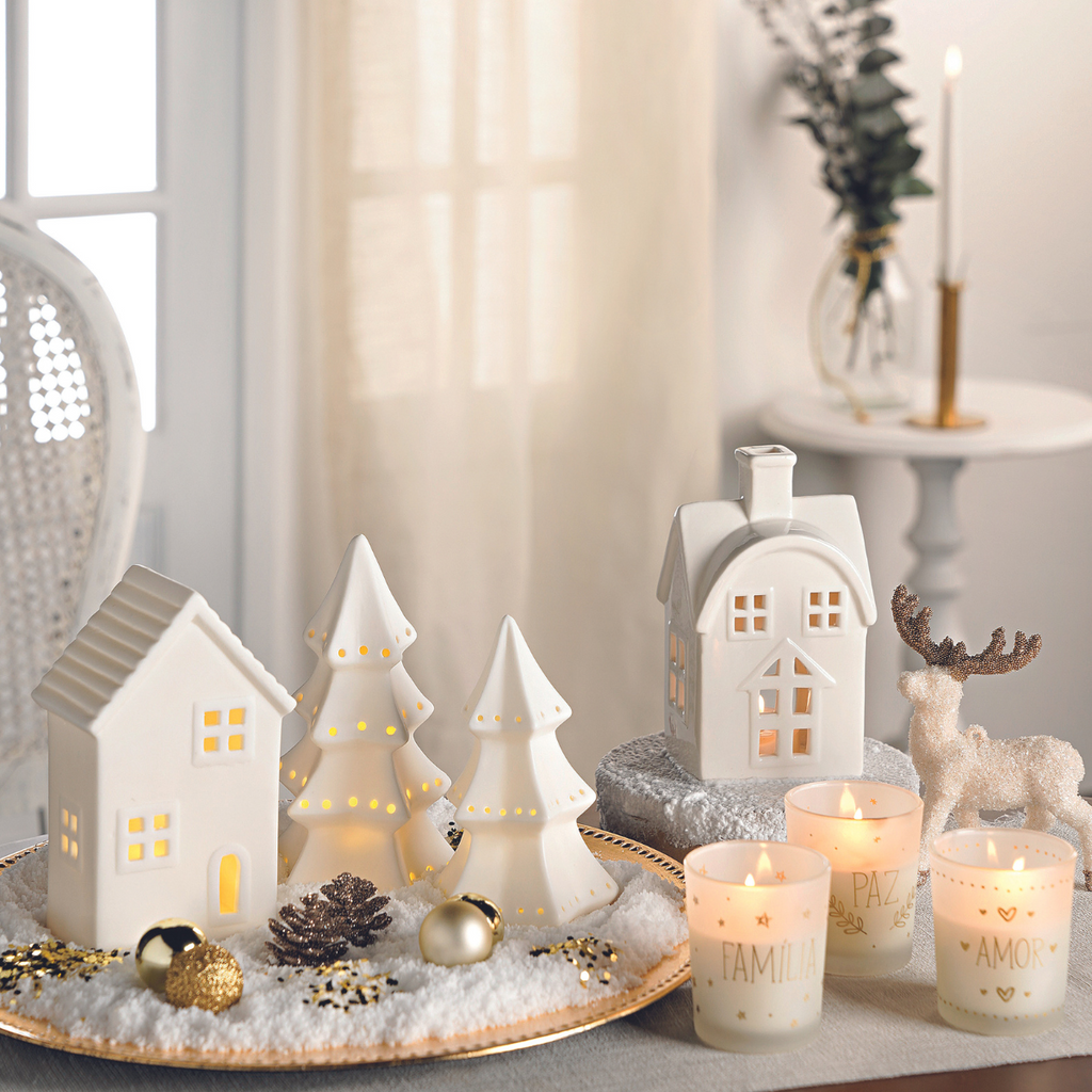 Copos com velas. Casas douradas para decoração de Natal.