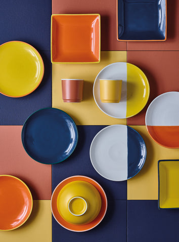 Pratos, canecas e taças da coleção Deep Rustic. Com padrões geométricos e cores como azul, amarelo e vermelho.