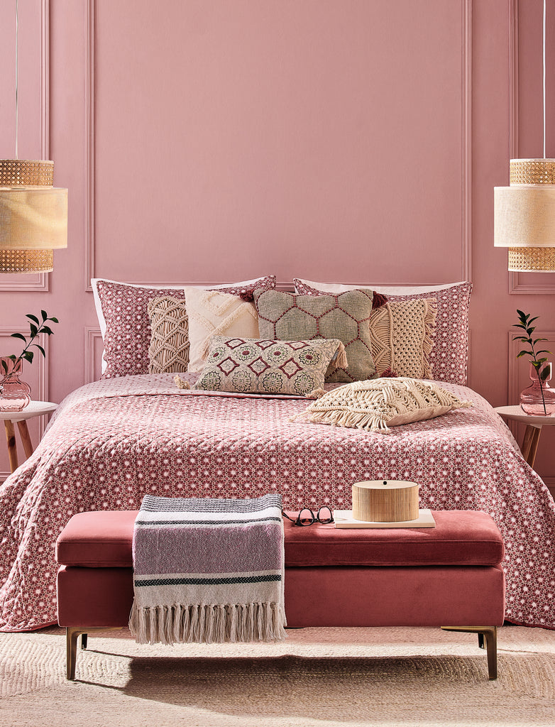 Quarto com cama de casal decorado com a coleção Coachella com Mesinhas de Cabeceira e uma Banqueta cor-de-rosa às pés. 