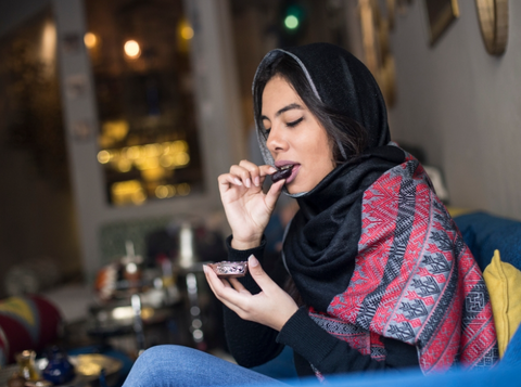 Woman in a Hijab eating dates