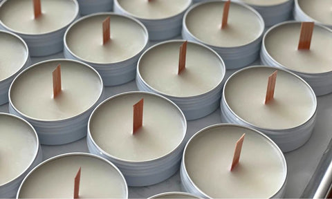 Candles in metal tins with wooden wicks