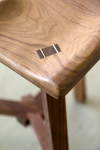 See-through tenon with contrasting maple pins on the seat of the wooden Conti stool by Martelo and Mo
