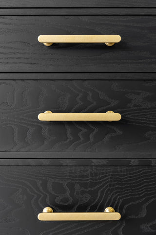 Close-up image of the antique brass drawer handles