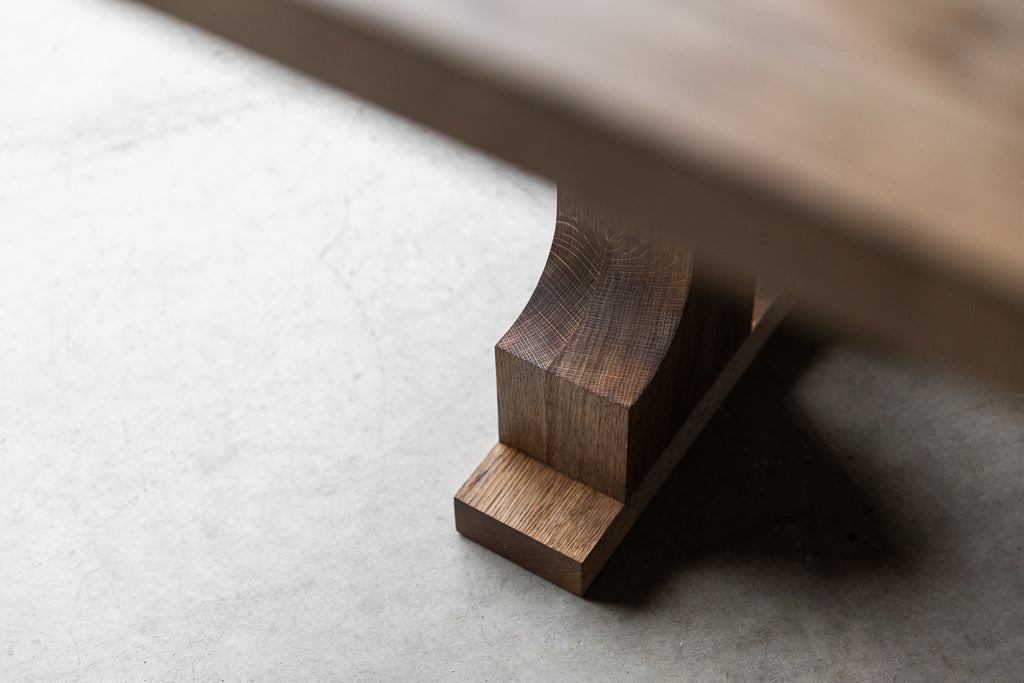 Close-up image of a dining table leg detail in aged Oak