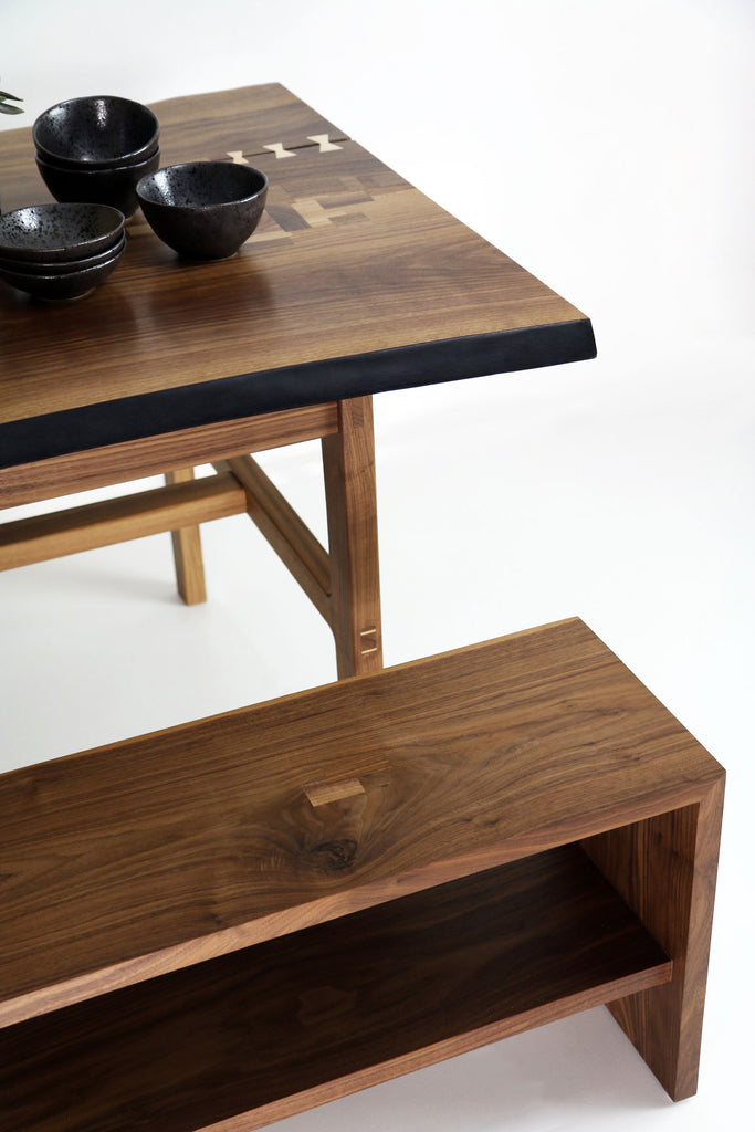 View of a Walnut dining table with live edge and a walnut dining bench by Martelo and Mo