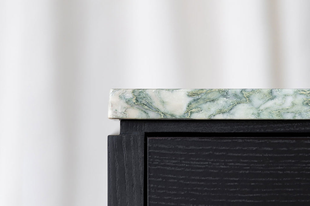 Close-up view of the Rosa bedside cabinet front, showing a shadow gap between marble top and a top drawer front