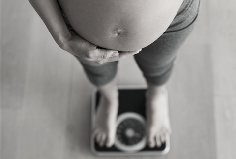 Pregnancy weight gain and woman on scales