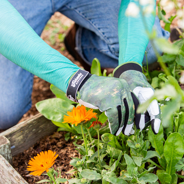 Gloved hands tending to the garden.