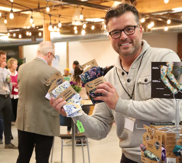 A participant holding the Farmers Defense sleeves in their packaging. 