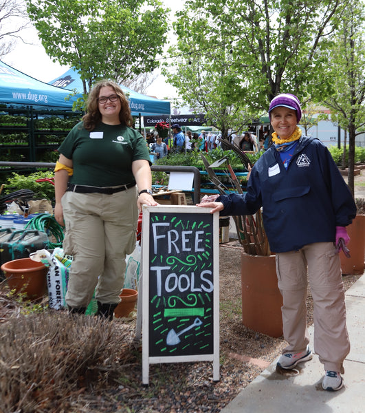 Workers at the event standing next to a sign that reads: "Free Tools"