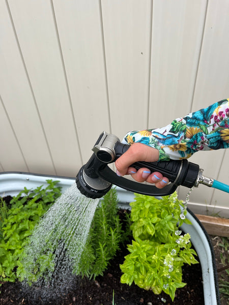 A woman wearing Farmers Defense Sleeves while watering plants.